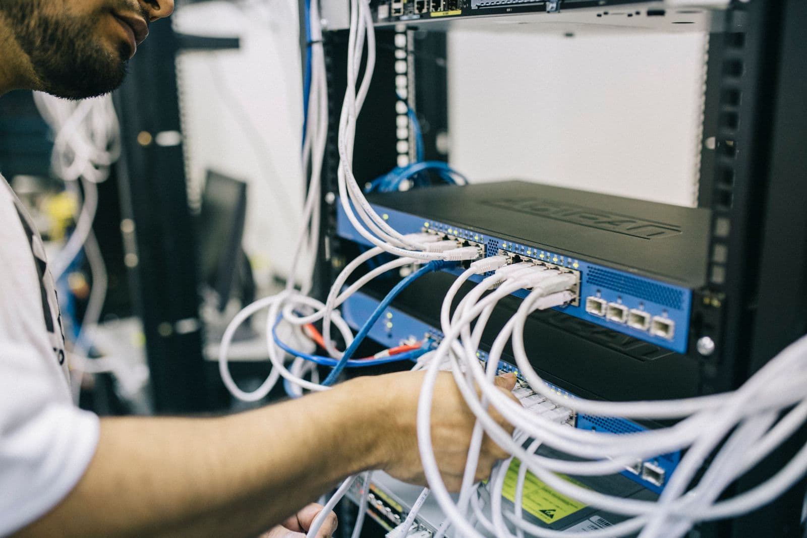 Kỹ sư IT đấu nối cáp mạng trong tủ rack phòng máy chủ doanh nghiệp